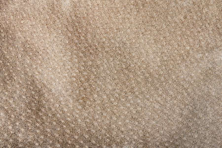 Texture backdrop photo of brown colored suede leather material, close-up view.