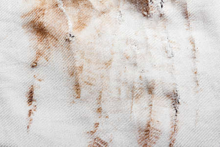 Texture backdrop photo of brown stained, burned and damaged old white colored cloth.の写真素材