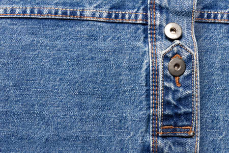 Texture backdrop photo of blue colored denim cloth with belt and buttons.