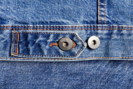 Texture backdrop photo of blue colored denim cloth with belt and buttons.の写真素材