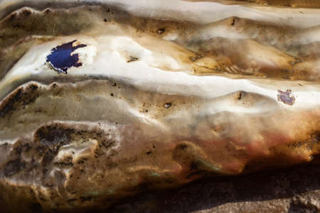 Close-up photo texture of copper or bronze statue material with folds.