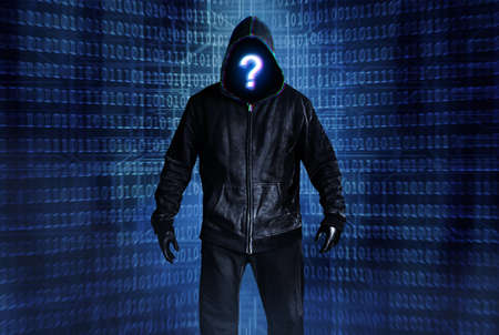 Photo of hacker person in black hood and clothing on digital binary code background.