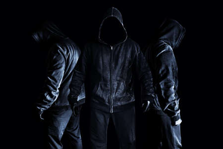 Photo of scary horror stranger stalker men in black hood and clothing on dark and misty background.の写真素材