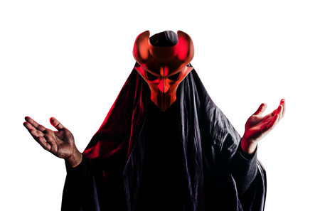 Isolated scary horror occult sectarian priest in black hood and metal mask on white background.の写真素材