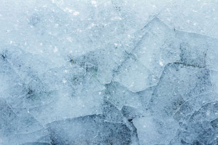 Close up photo of cracked frozen snow ground covered in ice texture background.の写真素材