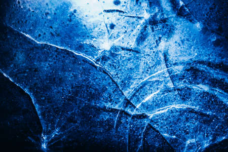Photo of blue toned frozen circle cracked ice surface texture.の写真素材