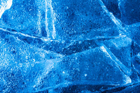 Photo of blue toned frozen cracked ice pieces surface texture.の写真素材