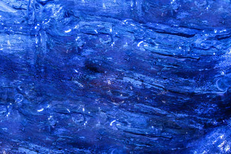 Photo of blue toned frozen wood trunk covered in ice texture.の写真素材