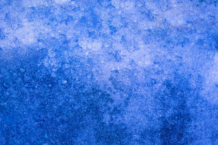 Photo of blue toned frozen snow covered in ice surface texture.の写真素材