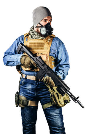 Isolated photo of urban soldier in tactical military outfit and gas mask standing with rifle and gas mask white background.の写真素材