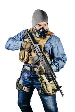 Isolated photo of urban soldier in tactical military outfit and gas mask standing with rifle and gas mask white background.の写真素材