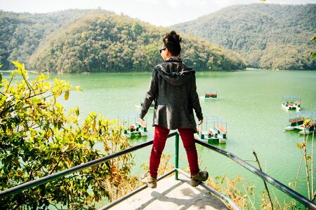 Back of the girl standing in front of the lake in pokharaの写真素材