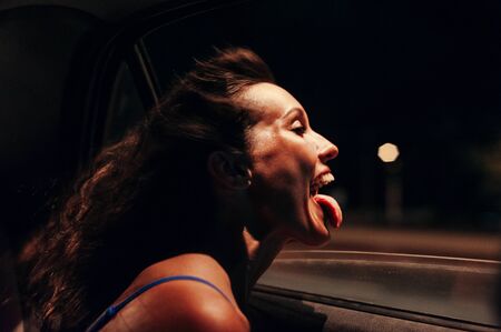 Girl sticking her tongue out in the move carの写真素材