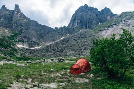 Camping with a red tent in the mountains in Russia, ergakiの写真素材