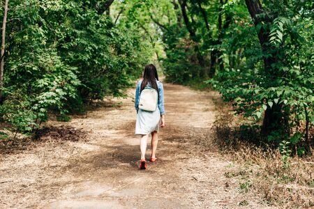 girl walking along a sandy path in the city parkの写真素材