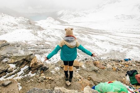 Landscape with girl, high mountains with snowy peaks, path, blue sky in Nepal. Travel.