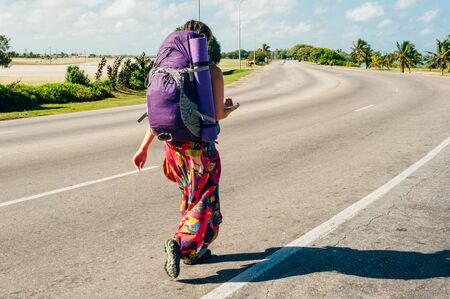 Cute latin American woman hitchhikingの写真素材