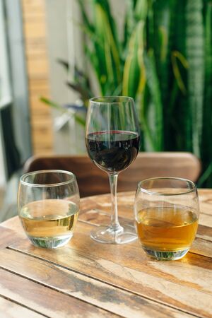 Glass of white and red wine on vintage wooden table in restaurantの写真素材