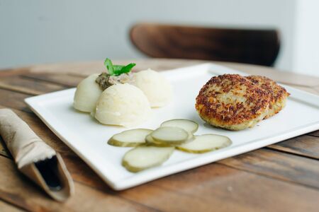 vegetarian cutlets with mashed potatoes and pickles on wooden table