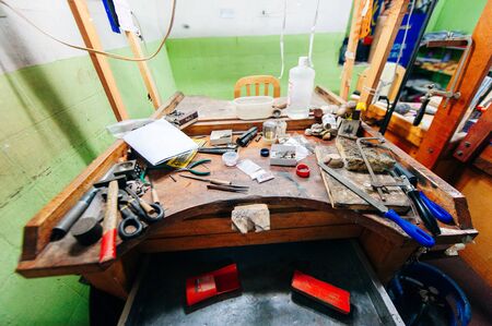 Ecuador - august, 2019 Top view of different goldsmiths tools on the jewelry workplace. Desktop for craft jewelry making with professional toolsのeditorial素材
