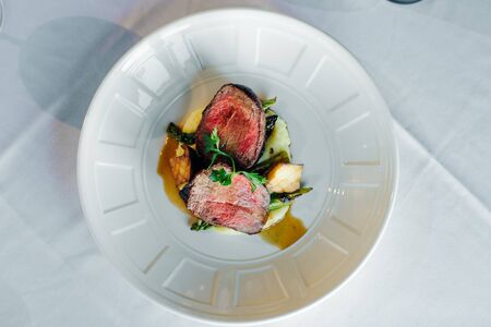 Closeup of a steak with vegetables in a restaurant setting. FILET MIGNON.