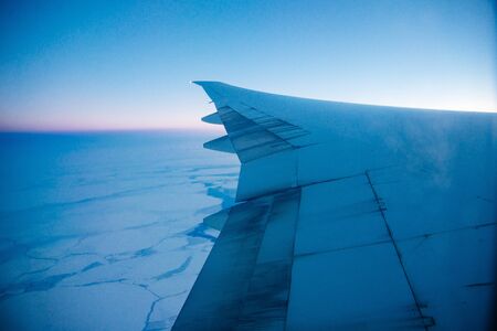 Aerial photo of the landscape with clouds, snowy mountains and view stretching all the way to the horizon.の写真素材