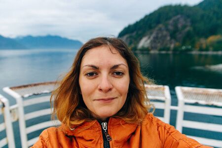 Traveler makes selfie on the background of the lake. Vancouver, Canada.