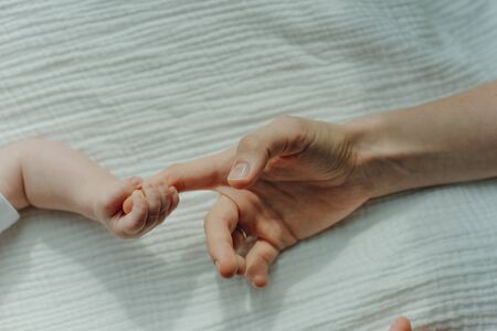 Newborn children's hand in mother hand. Mom and her Child.