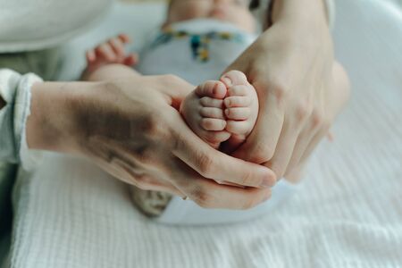 Legs newborn baby and Mama's arms heart.の写真素材