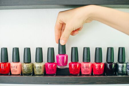usa, la - january, 2020 girl holds nail polish on the background of nail polishes.のeditorial素材