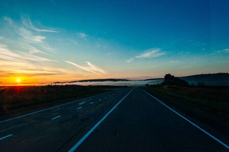 Sun Rising Above Asphalt Open Road In Sunny Sunrise Morning.