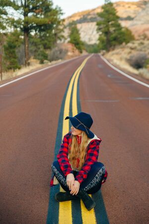 girl sitting on the road in Zion National Park in southwestern Utah near the town of Springdale.