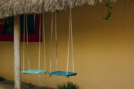 turquoise swing with a yellow wall.の写真素材