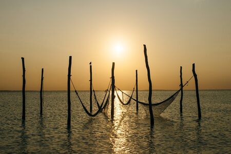 Relaxing in a hammock over the water, Isla Holbox, Mexico.の写真素材