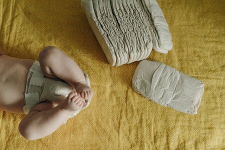 Baby wearing a white reusable diaper. Baby taking care and hygiene concept.