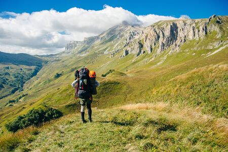 tourist hiking in the mountains with large backpacks. Russia.