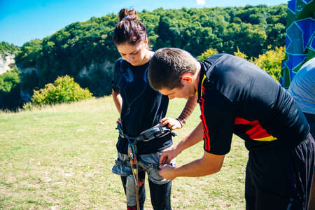 Close-up of mountaineer with trad climbing, slings and carabiners preparing for ascent in summer mountainsのeditorial素材