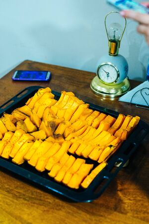 Slices of baked orange pumpkin with honey and cinnamon on a wooden table. Autumn warm dish as a dessert.の写真素材