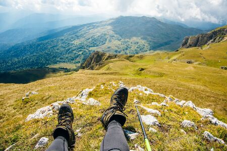 tired tourist concept. trekking boots against the backdrop of a beautiful landscape.