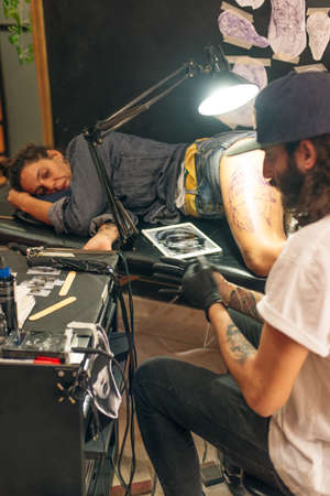 Tattoo artist workplace with machine and bottles with black tattoo ink.のeditorial素材