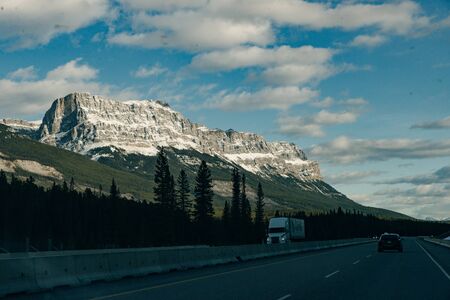 Scenic road through the Canadian Rockies, surrounded with rocky mountains. Taken in Banff National Park, Alberta, Canad.の写真素材