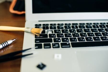 screwdriver and spare parts from a laptop. Keyboard, brush, keys. Laptop repair.の写真素材