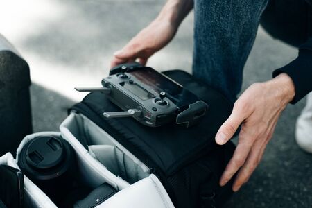 Drone remote control. Remote control in hand man. Man holds remote controller with his hands and controls the drone.の写真素材