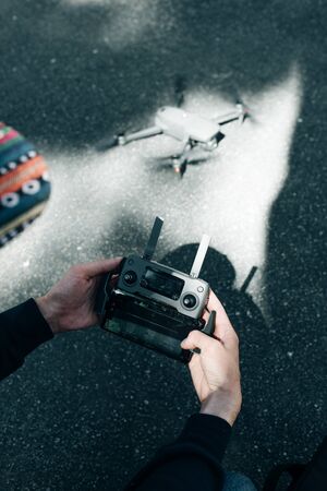 Drone remote control. Remote control in hand man. Man holds remote controller with his hands and controls the drone.の写真素材