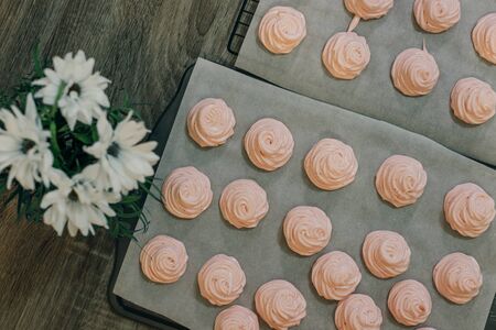 Homemade pink marshmallows on baking paper background on the kitchenの写真素材