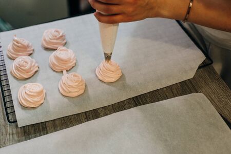 Homemade pink marshmallows on baking paper background on the kitchen.の写真素材