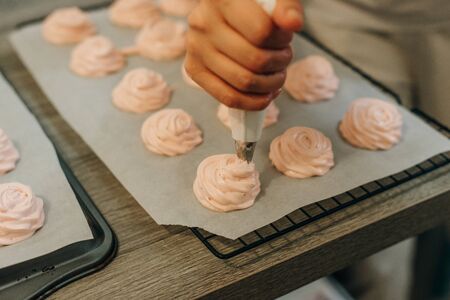 Homemade pink marshmallows on baking paper background on the kitchen.の写真素材