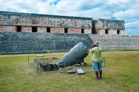 Ancient mayan wall with arches with green garden around in Uxmal, Mexico.の写真素材