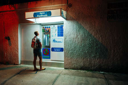 cancun, Mexico - October 2019 Back view of young male using ATM cash point.のeditorial素材