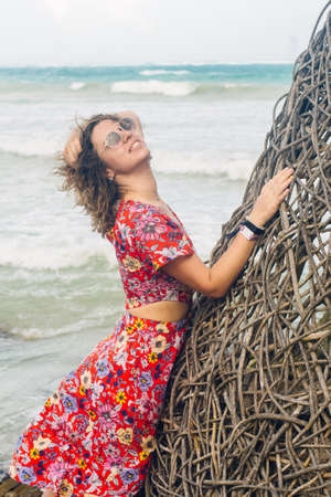 blonde in a bright dress on the background of the ocean